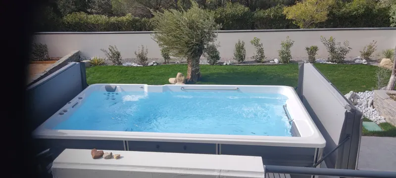 Spa de nage blanc rempli d'eau en extérieur