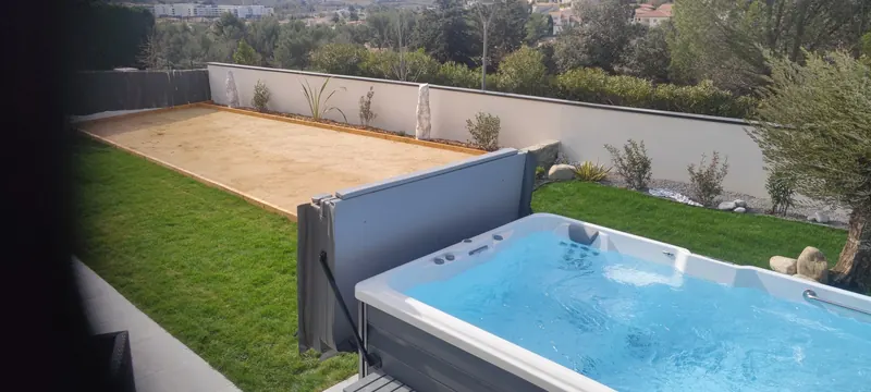 Spa de nage blanc vu de côté, avec la terrasse et l'écran de confidentialité