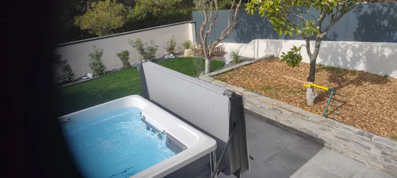 Spa de nage blanc dans le jardin, vu sous un autre angle