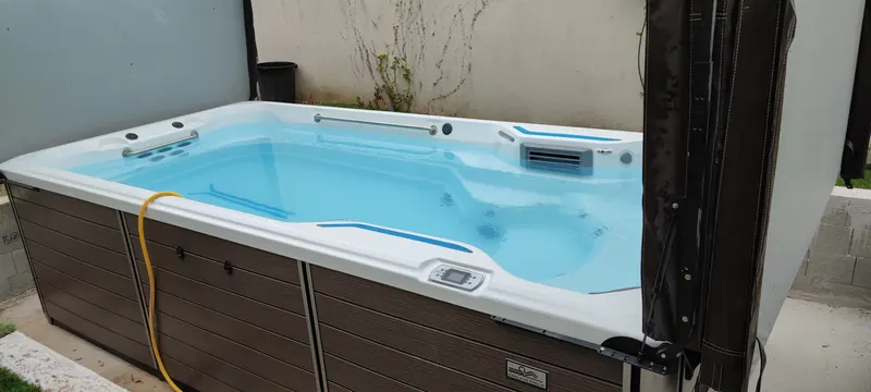 Spa de nage vu de dessus, eau turquoise, jets de massage visibles