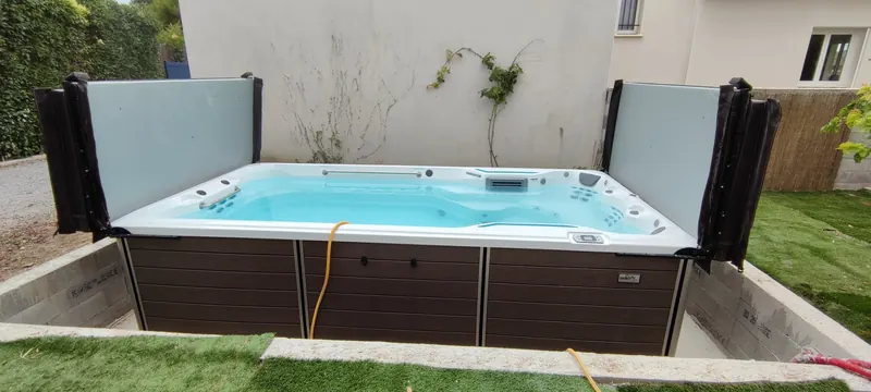 Spa de nage encastré dans le sol, avec un décor aménagé autour