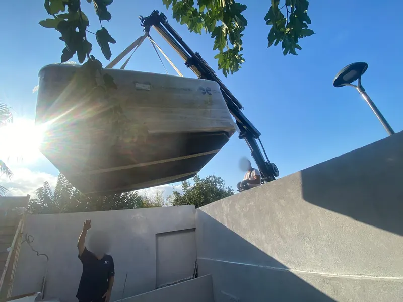 Spa blanc posé sur la terrasse carrelée après le levage