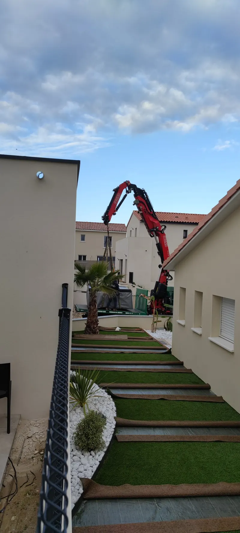Grue déployée au-dessus d'une cour entourée de maisons