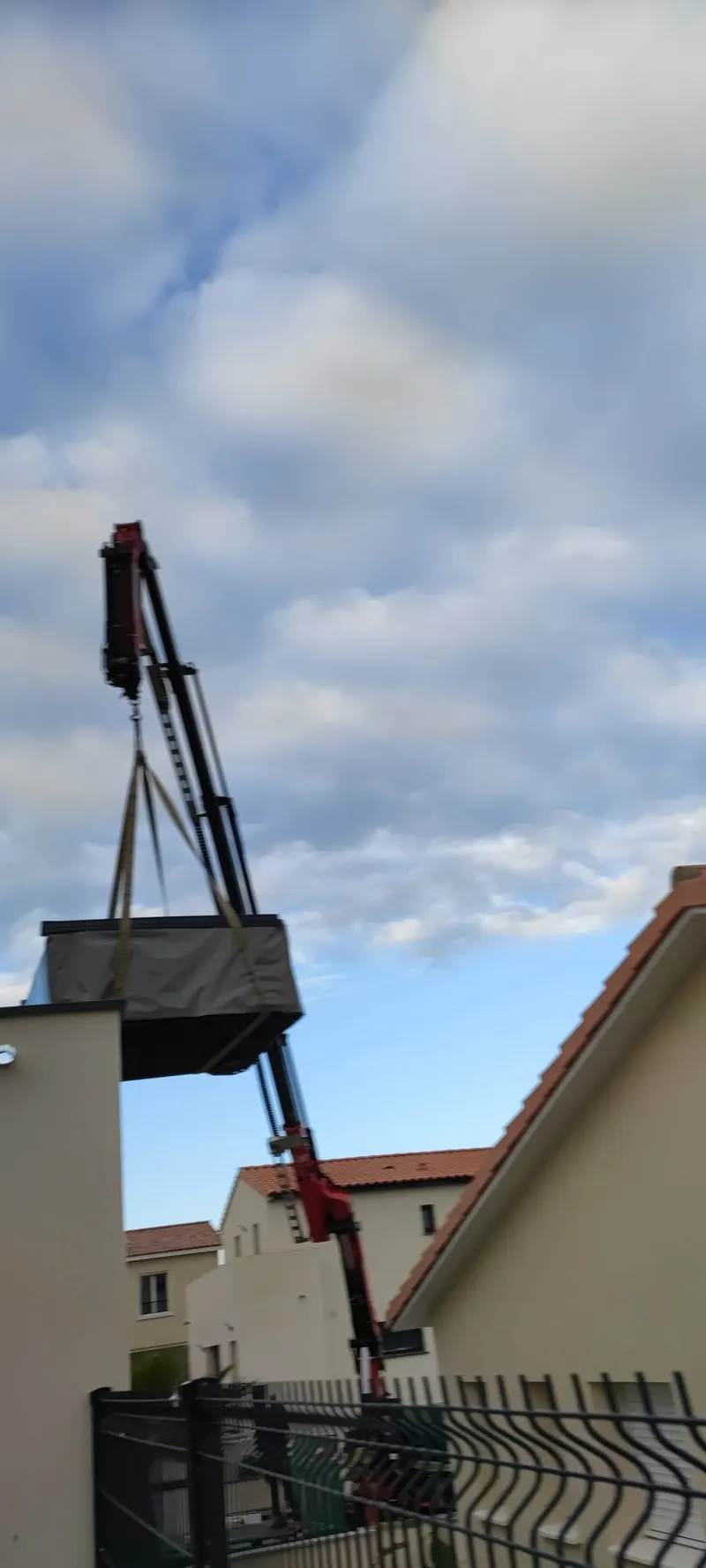 Levage du spa par la grue, dans l'accès étroit entre les bâtiments