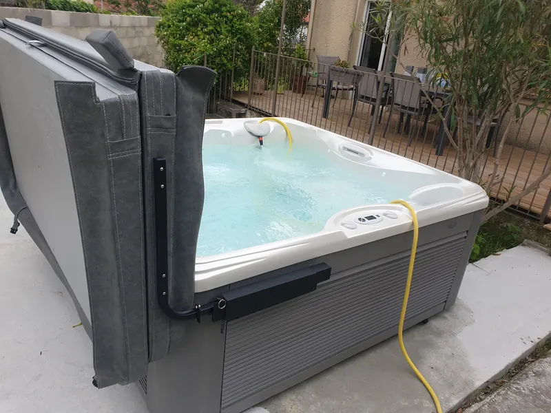 Spa blanc et gris sur la terrasse, couvercle gris baissé