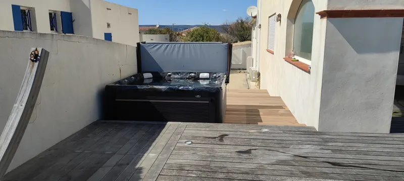 Vue d'ensemble : terrasse en bois, partie pavée, spa et paysage côtier