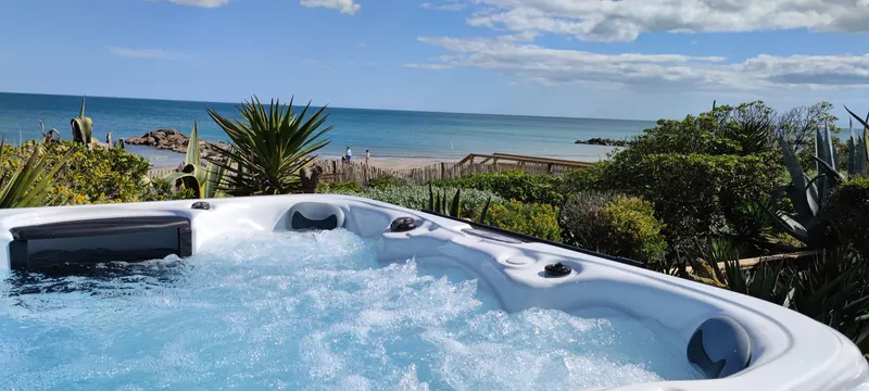 Spa en eau vu de plus loin, jets actifs, mer au fond