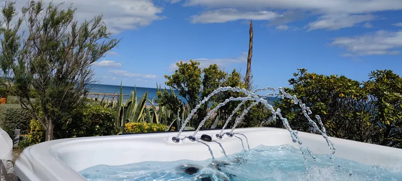 Jets d'eau en arcs, spa vu d'un autre angle, végétation derrière