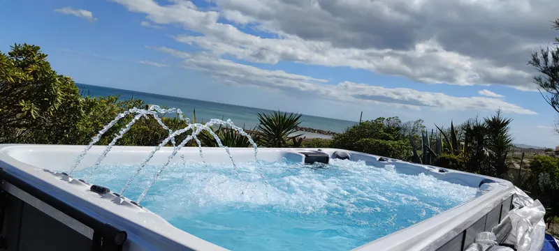 Arcs d'eau dans le spa, ciel nuageux et mer derrière