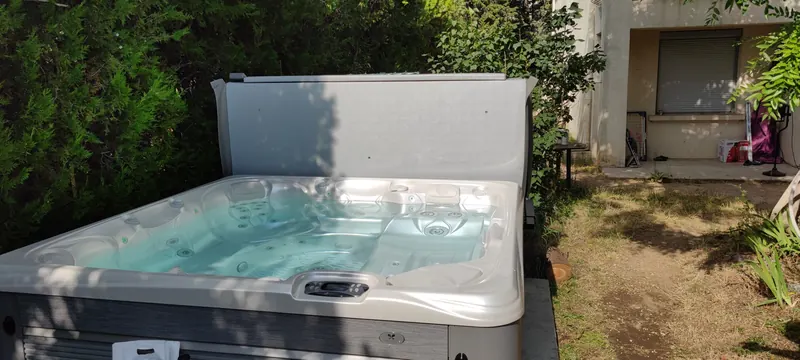 Spa blanc vu de face, avec ses jets et son escalier d'accès