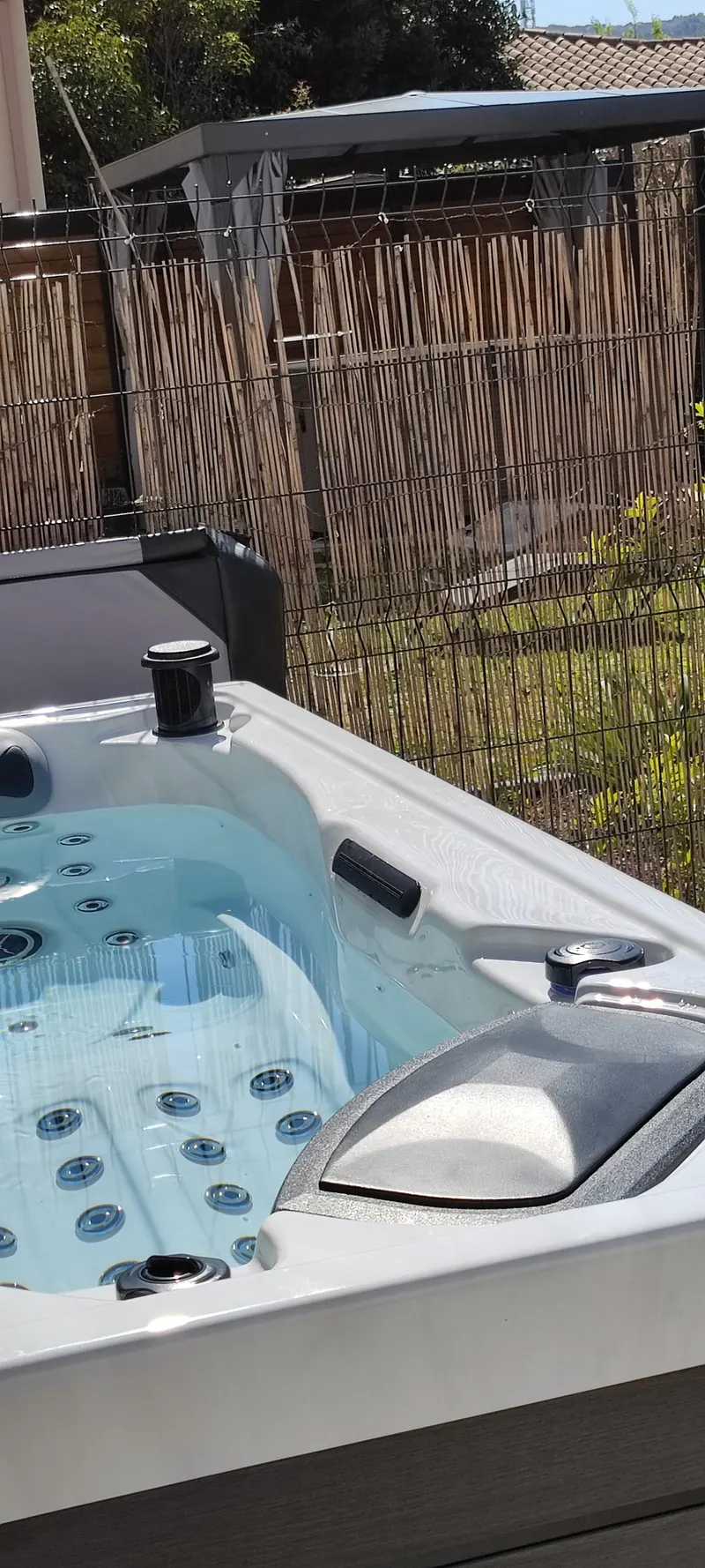 Détail du spa avec sa barrière métallique et son pare-vue