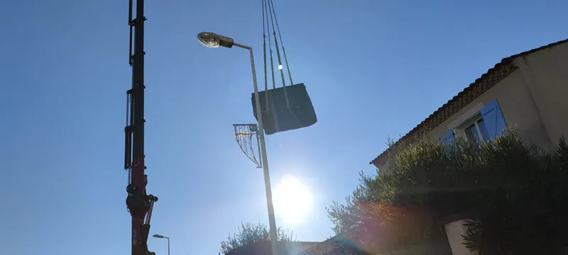 Spa suspendu à la grue au-dessus du toit, à côté d'un lampadaire