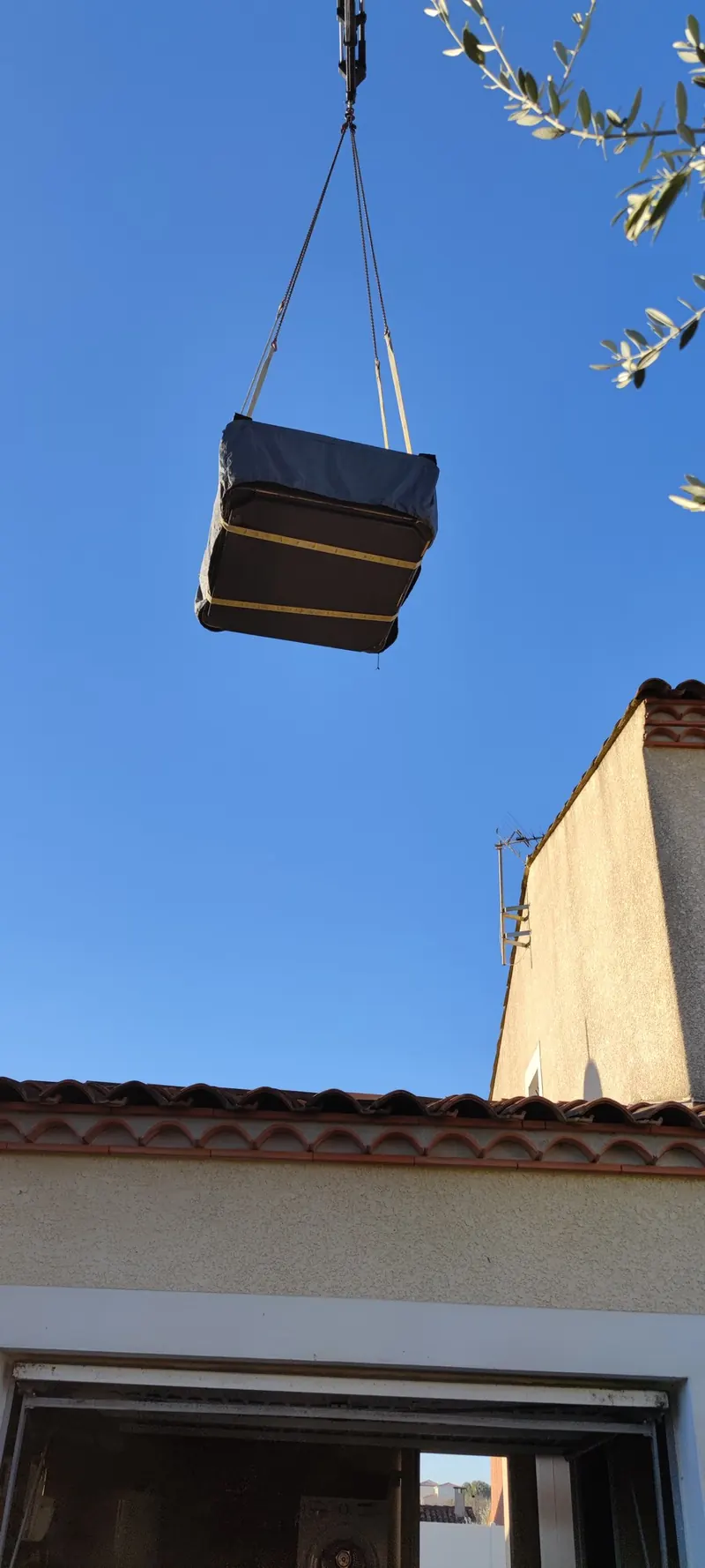 Spa sanglé passant à la grue au-dessus de la maison