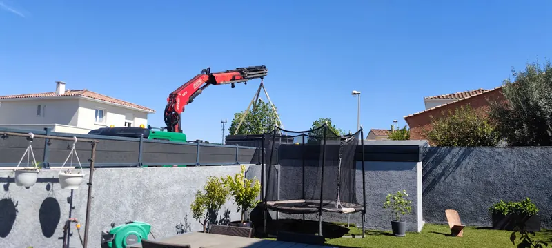 Le spa blanc au bout de la grue, au-dessus du jardin