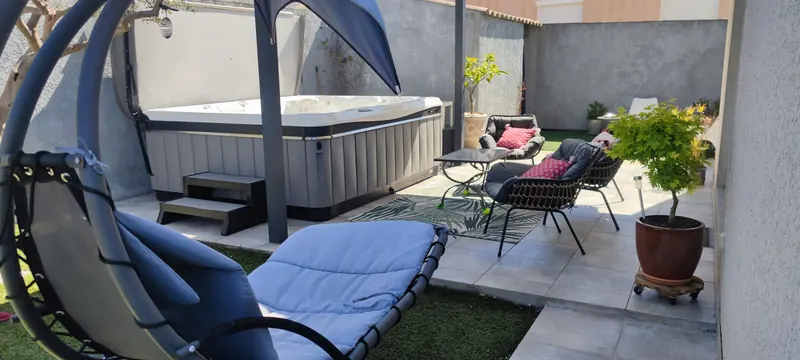 Vue rapprochée du spa blanc en place, avec un hamac