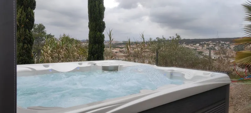 Détail du spa rempli, eau turquoise, équipements de filtration visibles