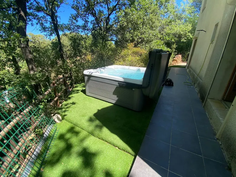 Spa blanc à l'intérieur, terrasse en bois et environnement boisé