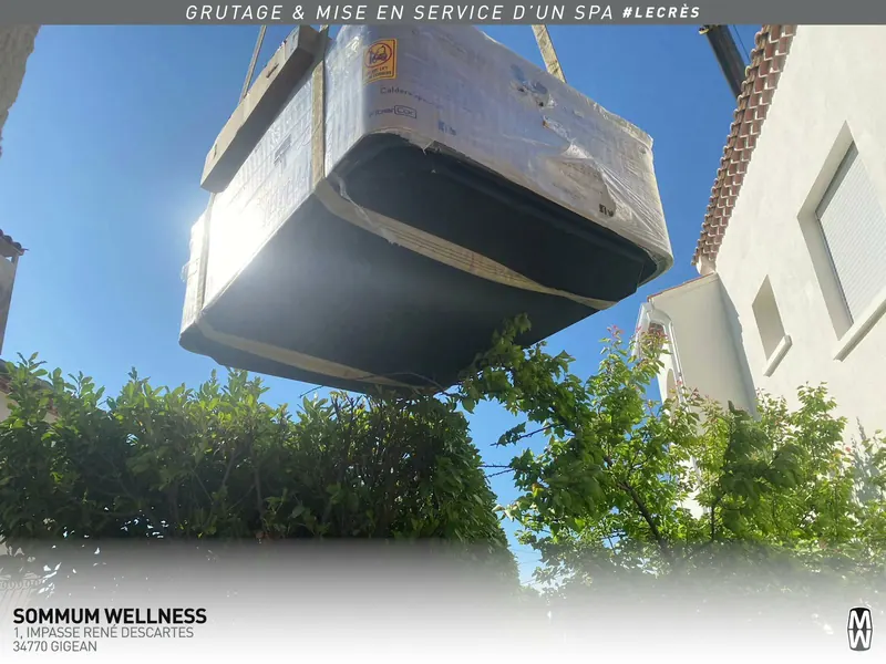 Spa emballé suspendu à la grue, vu d'en dessous