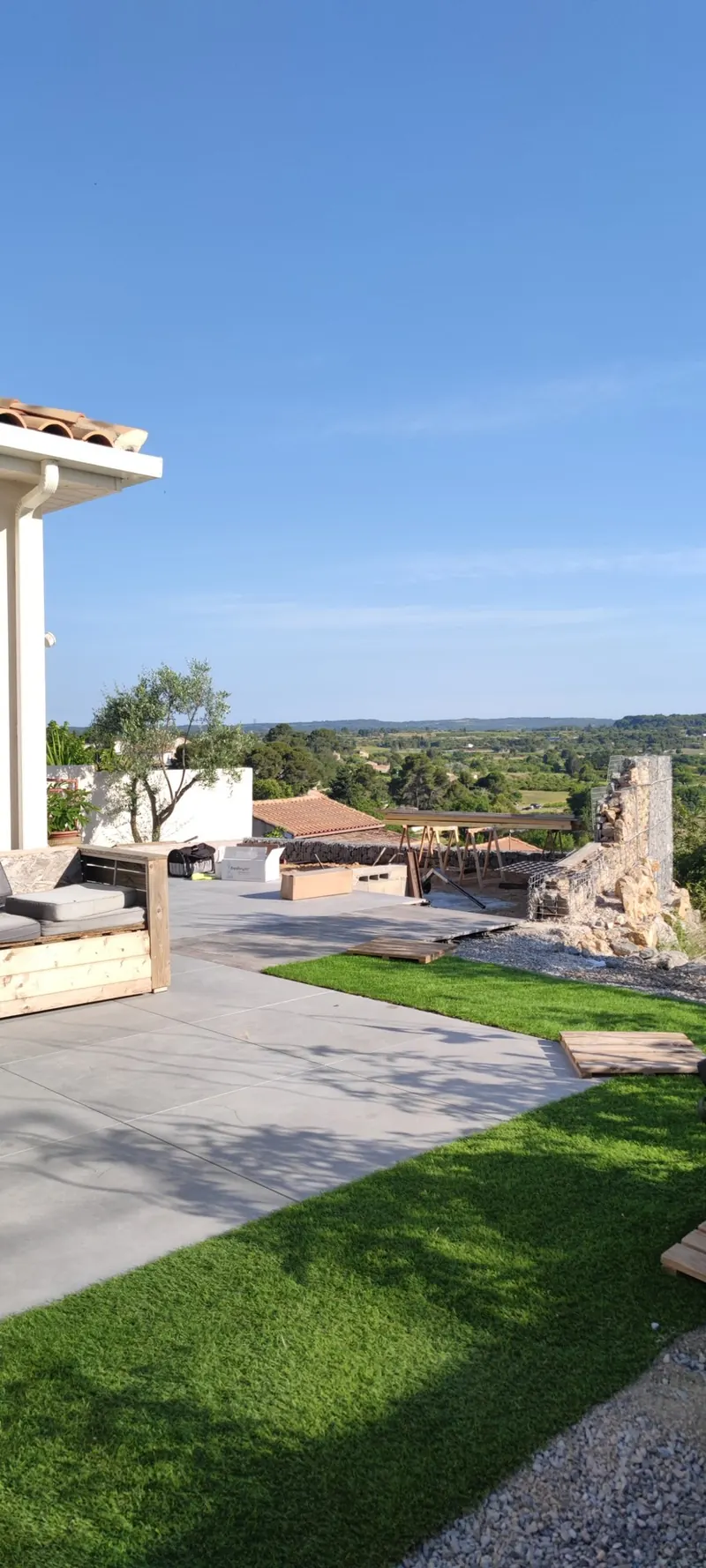Spa blanc posé sur une terrasse en béton gris, vue dégagée sur le paysage