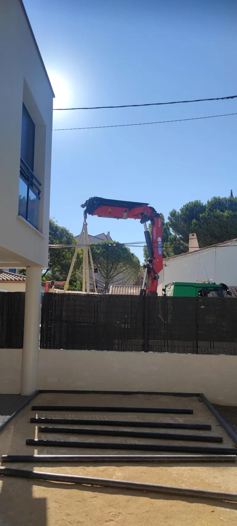 Spa dans sa coque de transport, suspendu à la grue au-dessus du jardin