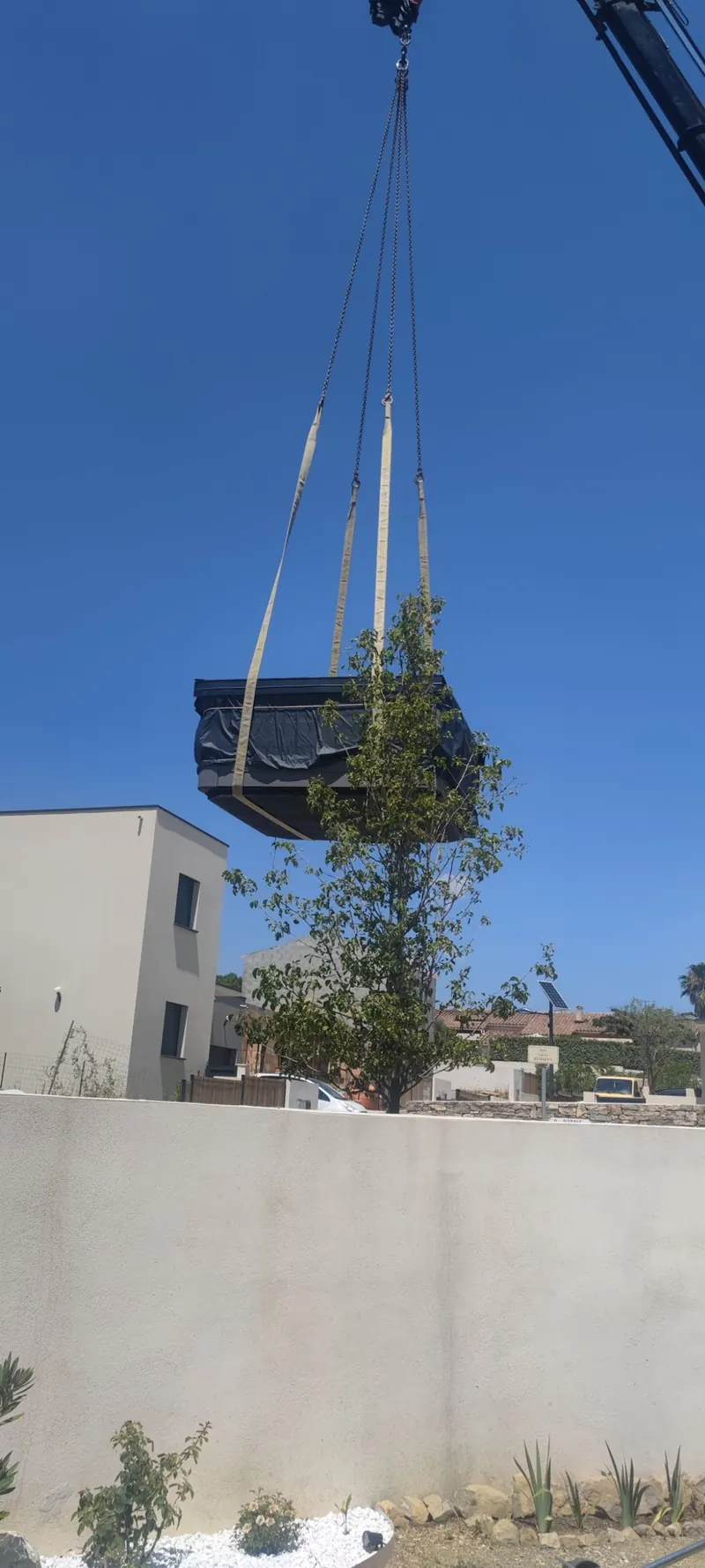 Spa suspendu à la grue au-dessus d'une cour blanche