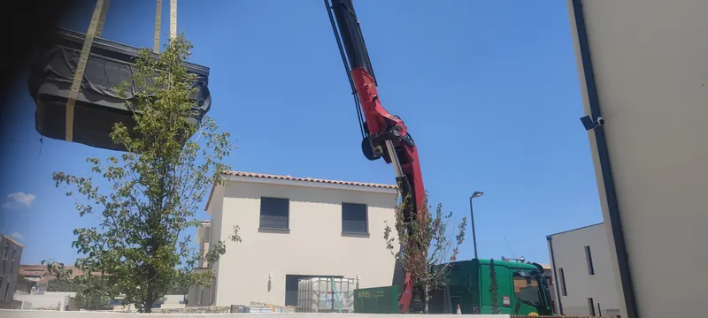Spa tenu par des élingues et descendu par une grue rouge, cadre résidentiel