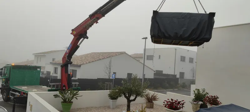 Spa suspendu à la grue pendant le levage vers le toit-terrasse