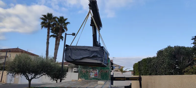 Spa suspendu à la grue, palmiers et toits de tuiles derrière