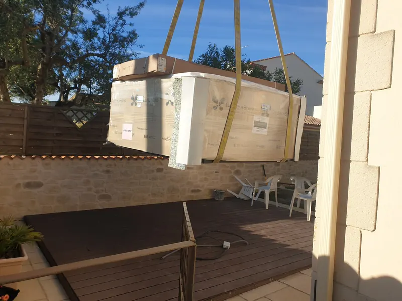 Spa dans son emballage blanc, suspendu à la grue