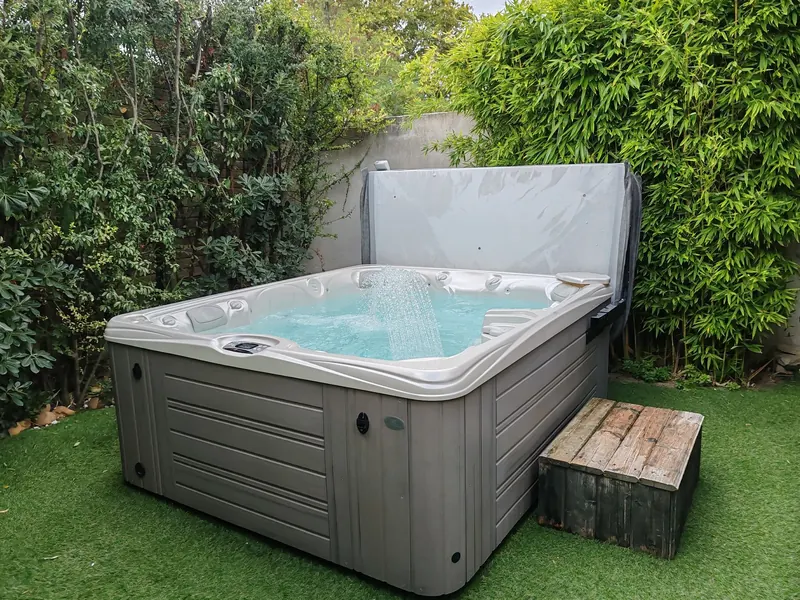 Eau turquoise en circulation dans le spa carré, posé sur de l'herbe synthétique