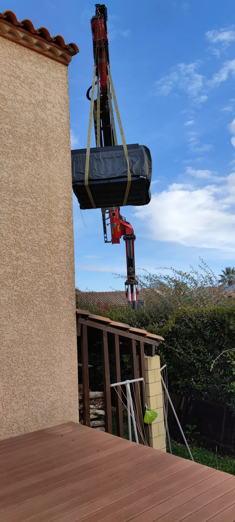 Spa enveloppé, suspendu à la grue contre la façade du bâtiment