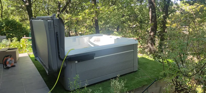 Spa blanc posé dans un jardin boisé aux arbres denses