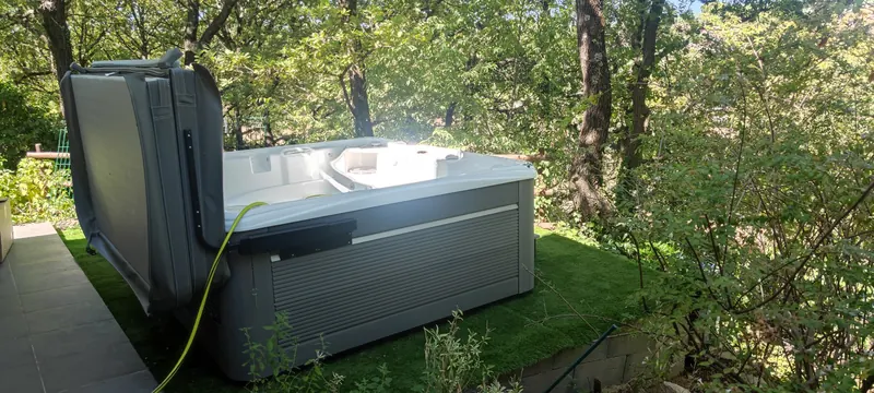 Spa de teinte claire, beige ou crème, au milieu d'un décor forestier