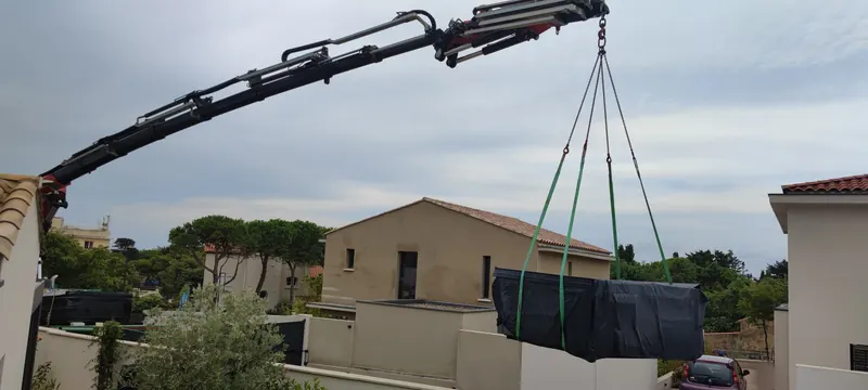 Spa gris posé sur une terrasse avec gazon, bordée de murs gris