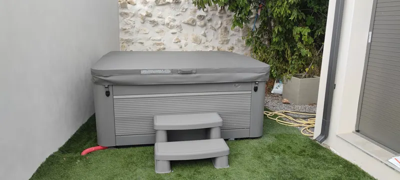 Spa gris en place dans la cour, finitions visibles