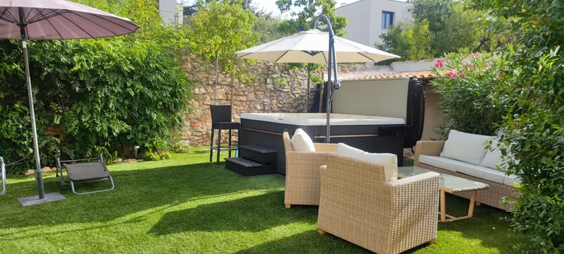 Spa blanc et noir avec un parasol, au milieu d'un jardin de pierre
