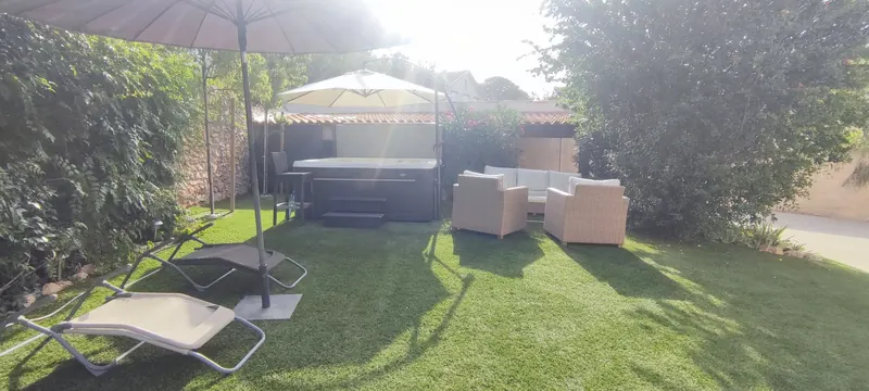 Vue latérale du spa dans le jardin, avec la pergola