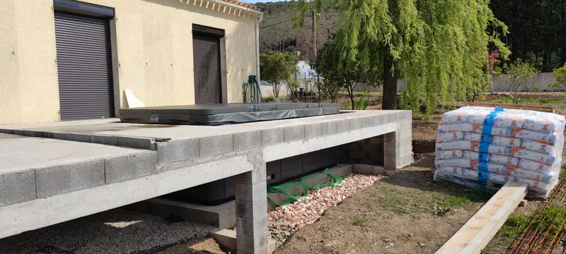 Détail de la dalle de béton préparée, matériaux empilés à côté
