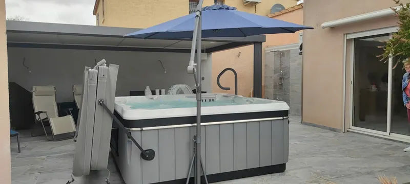 Vue en profondeur du spa, avec la pergola et les accessoires de détente