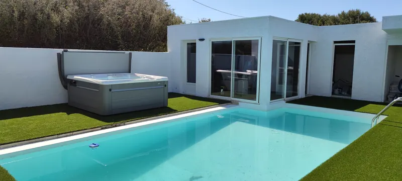 Vue générale du spa intégré entre un pavillon blanc et la piscine turquoise
