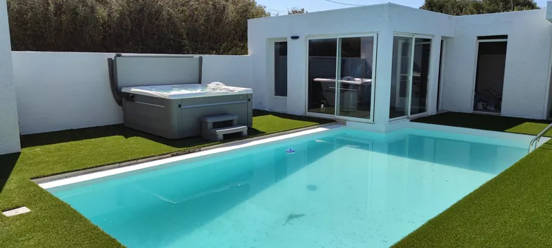 Spa avec clôture en bois, pavillon blanc et piscine à côté