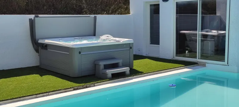 Spa fermé, terrasse en cours de mise en place, piscine au premier plan