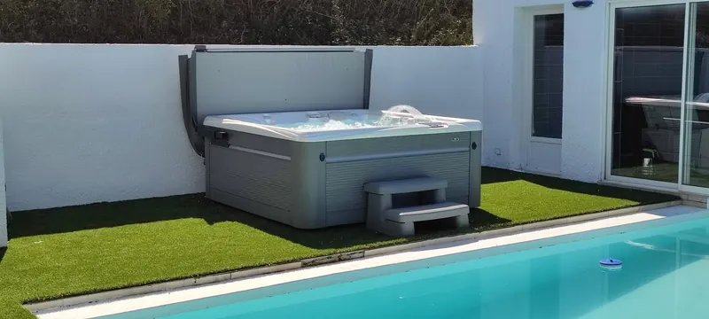Vue latérale du spa, couverture fermée, piscine turquoise